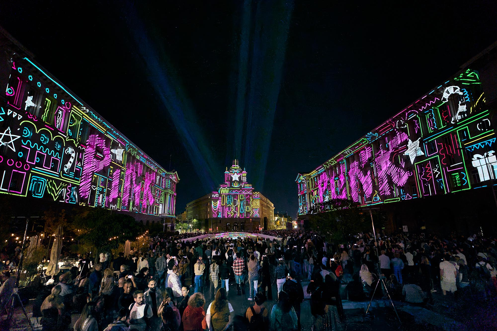 Multicolored geometric outlines mapped across the Largo at LUNAR 2026, Sofia
